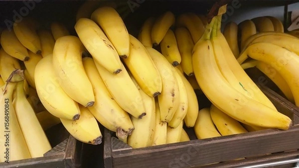 Fototapeta Fresh Bananas in a Wooden Box Display at a Market Ready for Customers to Purchase