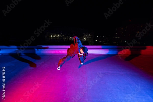 Obraz ビル屋上でアクロバティックなポーズを決めるダンサーの若者