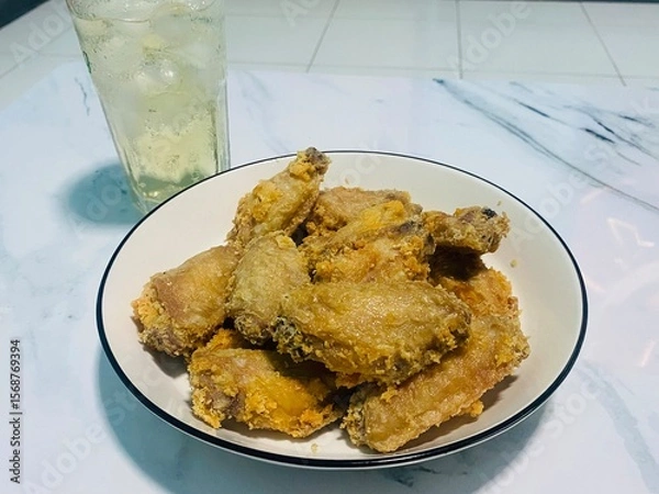 Obraz Fried chicken on a table with glasses of liquor and ice soda