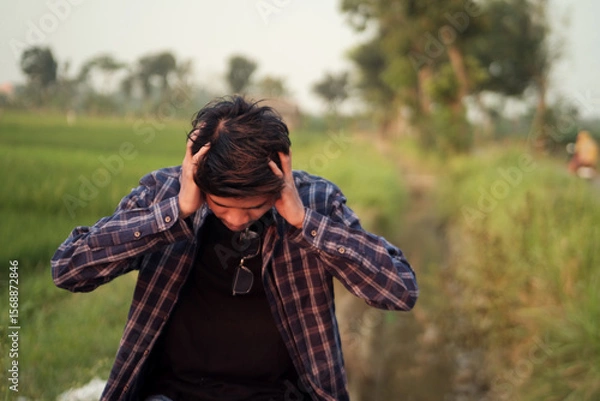 Fototapeta Man Experiencing Stress and Anxiety in a Rural Setting