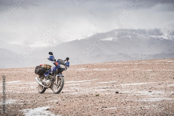 Fototapeta Motorcycle for tourism and off-road in the highlands of the Tien Shan in Pamir in cloudy weather
