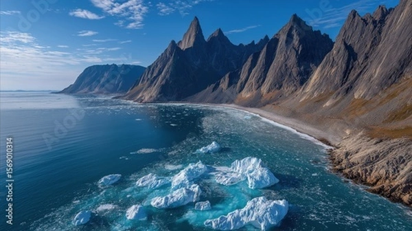 Fototapeta Majestic arctic landscape featuring floating icebergs along rugged coastal mountain range