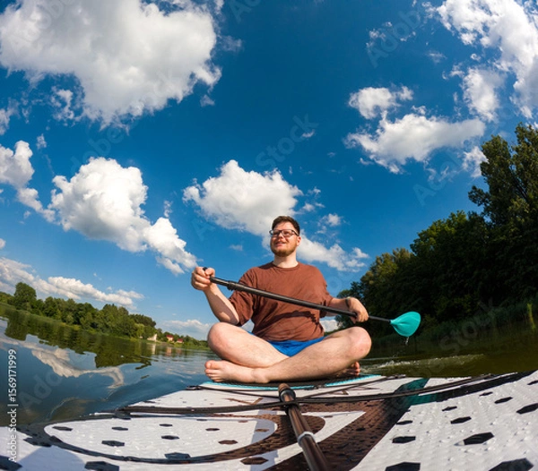 Fototapeta Man Taking Selfie on Paddleboard in Scenic Lake