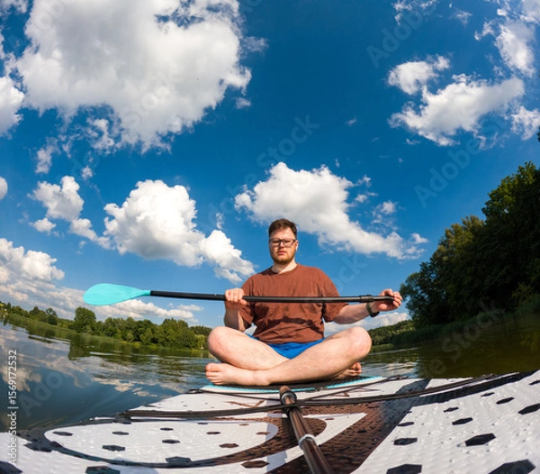 Fototapeta Man Taking Selfie on Paddleboard in Scenic Lake