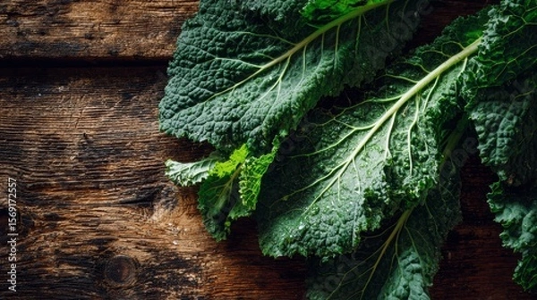 Fototapeta Fresh green kale leaves arranged on a rustic wooden table bathed in warm natural sunlight, showcasing organic farm freshness and vibrant textures