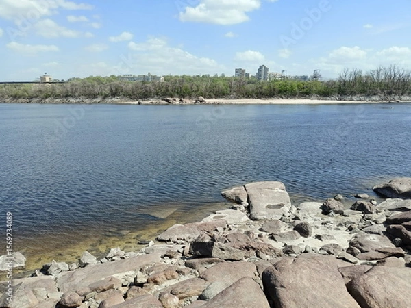 Fototapeta View from the rocky shore of Khortytsia Island to the buildings of Zaporizhzhia and the Dnieper Dam on the opposite bank of the river.