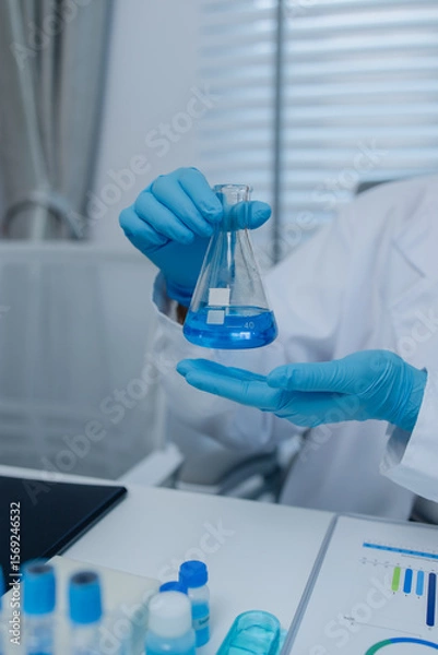 Fototapeta a female chemist is testing various liquid compounds in a lab, a scientist is doing research on the development of science in a lab, laboratory, test tube, scientific