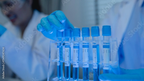 Fototapeta when in a lab, scientists wear lab coats, rubber gloves, and safety goggles, two chemists are testing chemicals in a liquid state, chemists working in a laboratory