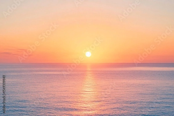 Fototapeta Peach-Colored Sky with Sun Setting Over the Ocean