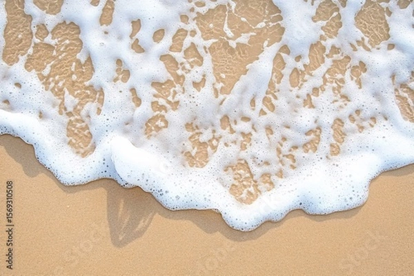 Fototapeta Ocean Foam Gently Rolling onto Warm Beach Sand