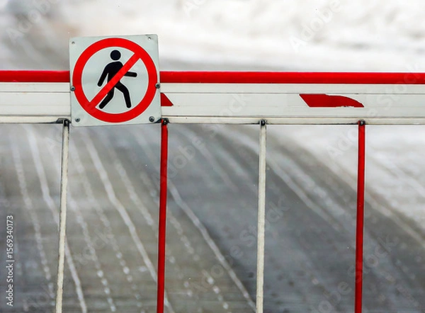 Fototapeta Barrier preventing pedestrian access on a snow-covered street in an urban area during winter