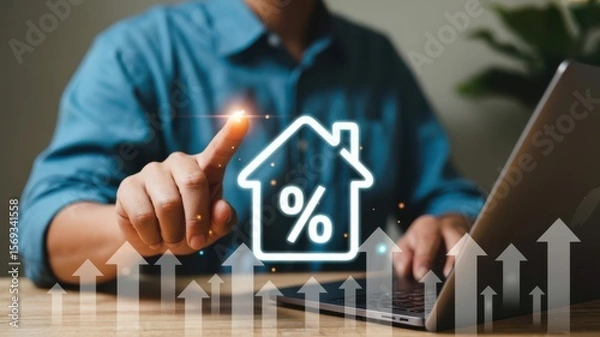 Fototapeta Man using laptop and pointing at digital house icon with percentage symbol and upward arrows representing real estate interest rates and market growth.