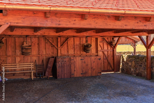 Fototapeta Rustic wooden carport and storage shed with red roof and brick flooring