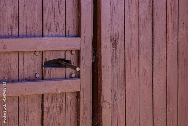 Fototapeta Rustic wooden door with metal latch in close-up view