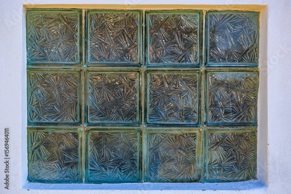 Fototapeta Patterned glass blocks in window frame with geometric designs