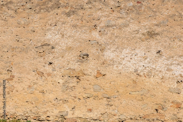 Fototapeta Weathered old stone wall texture with natural patterns and color variations