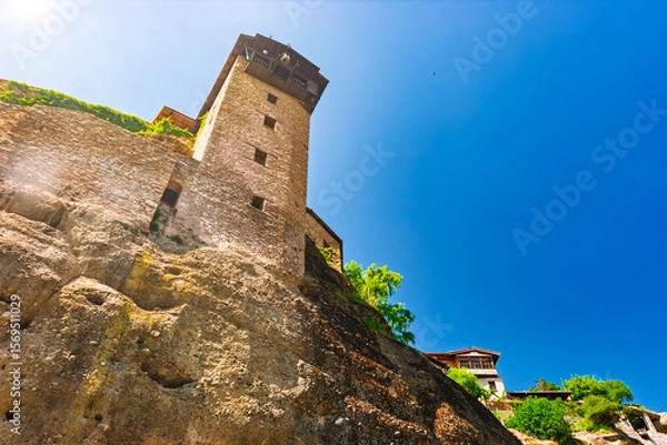 Fototapeta Meteora monastery tower built on dramatic cliffs under clear blue sky
