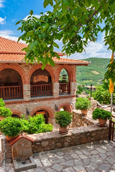 Fototapeta Brick and stone monastery building with potted plants  in Meteora Greece