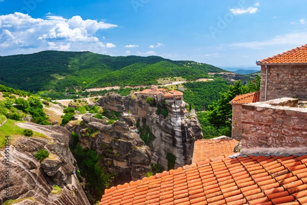 Fototapeta Elevated perspective over orange tiles toward Meteora monasteries on vertical cliffs in Greece