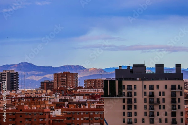 Obraz Various houses of a Spanish town against the backdrop of mountains under a cloudy sky	

