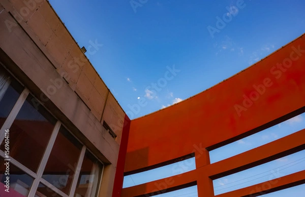 Fototapeta Geometric shapes of modern building facades with blue sky spaces