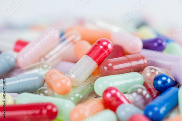 Fototapeta A macro shot of a colorful pile of medicine pills and capsules with a shallow depth of field. A pharmacy or healthcare background.