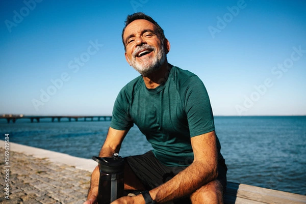 Fototapeta Smiling man enjoying outdoors by a scenic waterfront setting