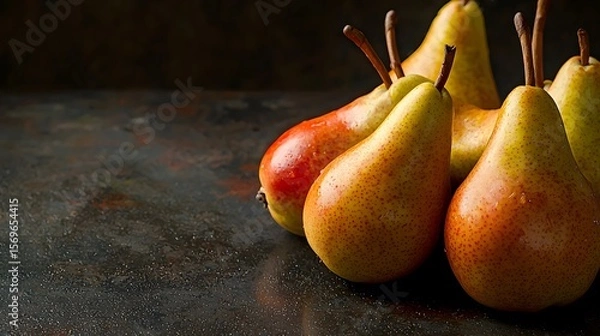 Fototapeta A cluster of ripe, juicy pears sits on a dark rustic surface providing ample copy space for text ideal for culinary websites blogs or food packaging designs showcasing the