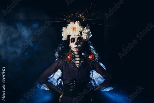 Fototapeta Woman with mexican skull halloween makeup on face. Day of the dead aka Dia de los Muertos and halloween concept.
