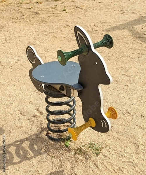 Fototapeta Vista de cerca de un balancín infantil con forma de conejo en parque público.