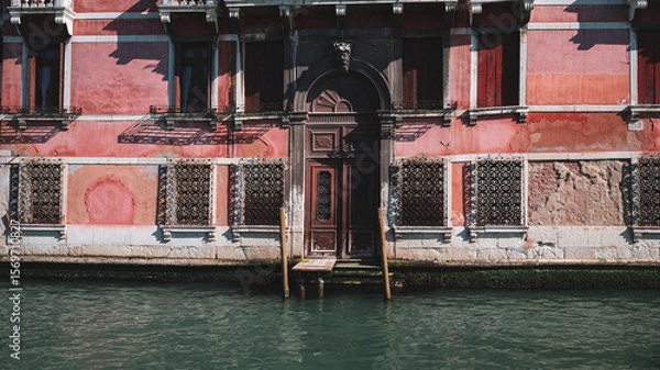 Fototapeta Weathered waterfront building with a canal view in Venice