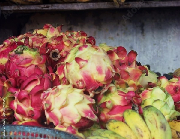 Fototapeta Pile of Dragon Fruit and Bananas at Market Stall