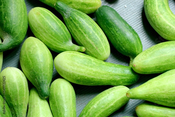 Fototapeta Fresh Green Cucumbers Displayed on Surface Ready for Use