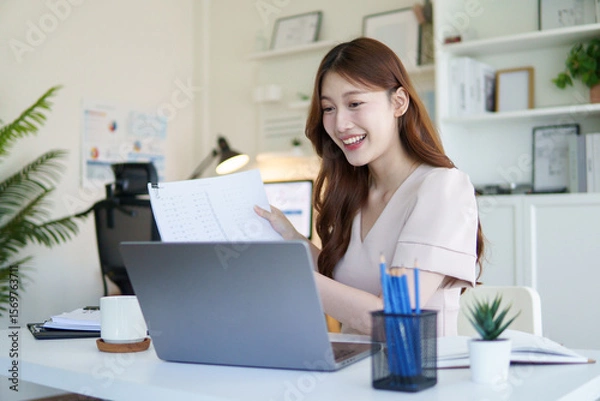 Fototapeta Smiling businesswoman explaining during a video conference call from her home office.