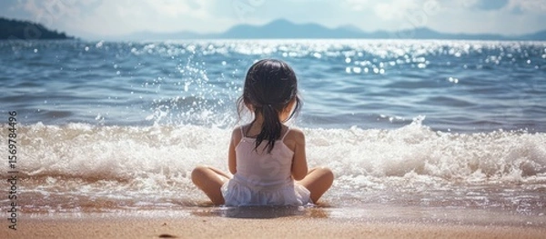 Obraz Child sits on beach, ocean view