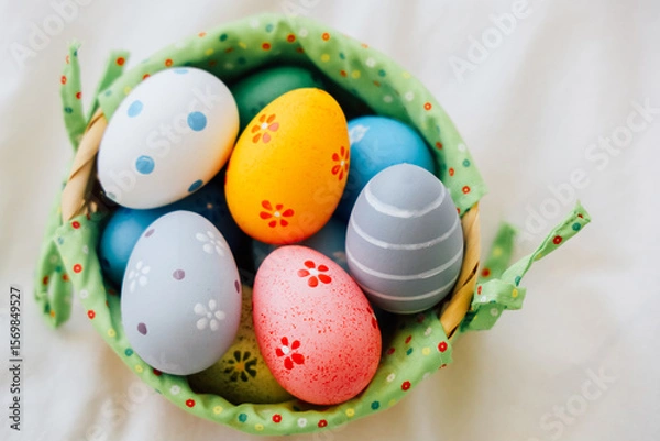 Obraz Colorful decorated eggs in a green basket for spring festivities