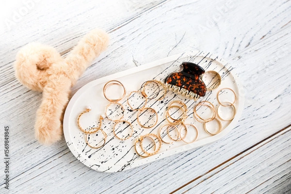 Obraz Colorful jewelry arrangement on a decorative tray with a plush accessory in a cozy setting