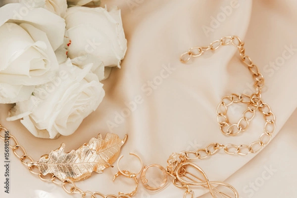 Obraz Elegant gold chain and rose arrangement on soft fabric during a romantic event preparation