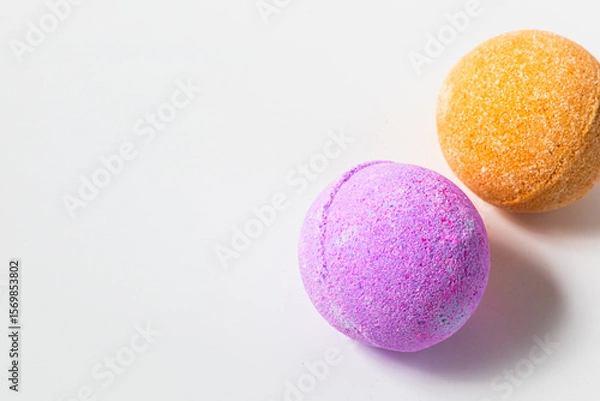 Obraz Vibrant bath bombs in shades of purple and orange resting on a clean surface