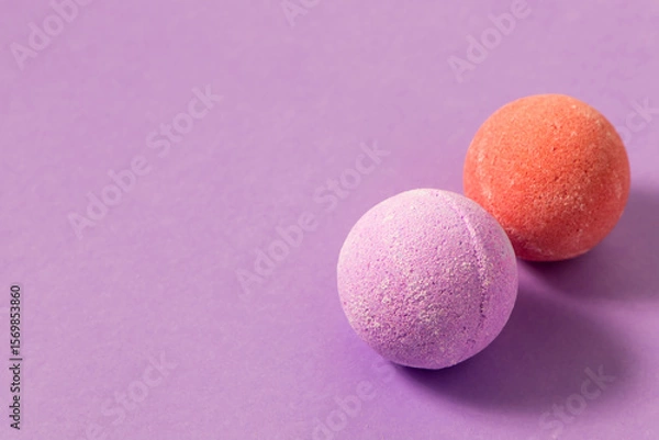 Obraz Colorful bath bombs placed on a light purple surface during a relaxing spa moment