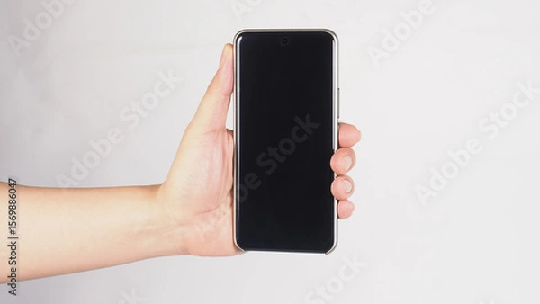 Fototapeta a smartphone vertically with one hand on white background.