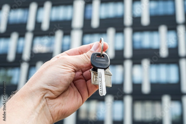 Fototapeta Business Lease Concept: Hand Holding Keys in Front of Office Building