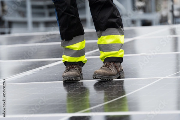 Obraz Solar panel rooftop, Rooftop solar power. Engineer or technicians maintaining and repairing solar panel on rooftop of building. Male engineer install solar cell on rooftop