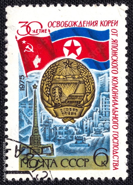 Fototapeta Flags of the USSR and North Korea. Coat of arms of North Korea. Postage stamp printed in the USSR in 1975, dedicated to the 30th anniversary of the liberation of Korea.