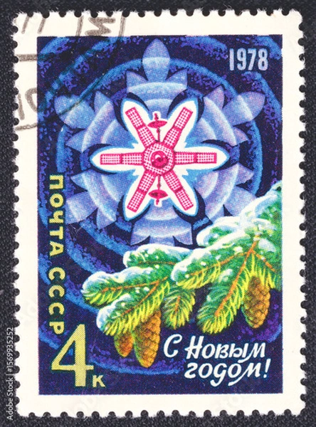 Fototapeta Space artificial satellite of the Earth, snowflake, Christmas tree branch and inscription Happy New Year on a 1977 USSR postage stamp. 
