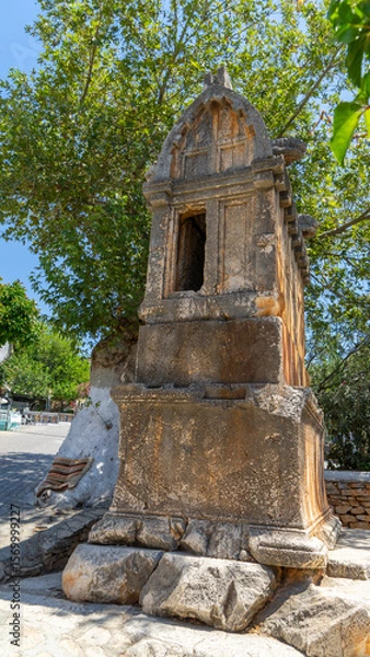 Fototapeta Stone sarcophagus of royal or lion's Lycian tomb made of solid rock. Drywall sarcophagus with handles in form of lion heads on street in Kas, Turkey. Vertical image