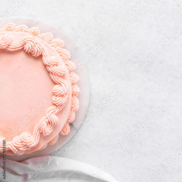 Obraz Pink buttercream cake on a cake plate, Cake covered in pink frosting, process of decorating top of cake with pink buttercream