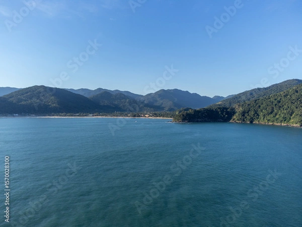 Obraz Setting sun on beautiful tropical beach amidst forested mountains