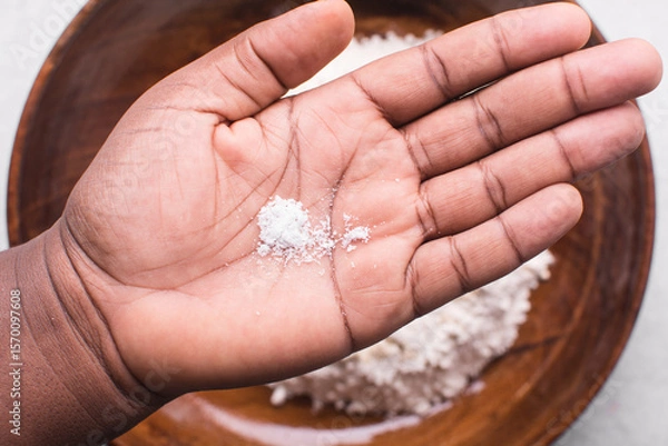 Obraz Overhead view of table salt in palm