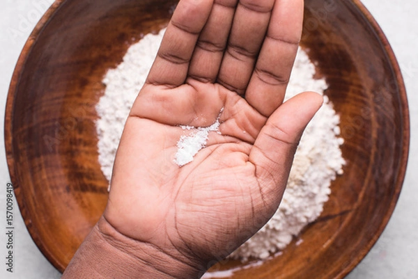 Obraz Overhead view of table salt in palm